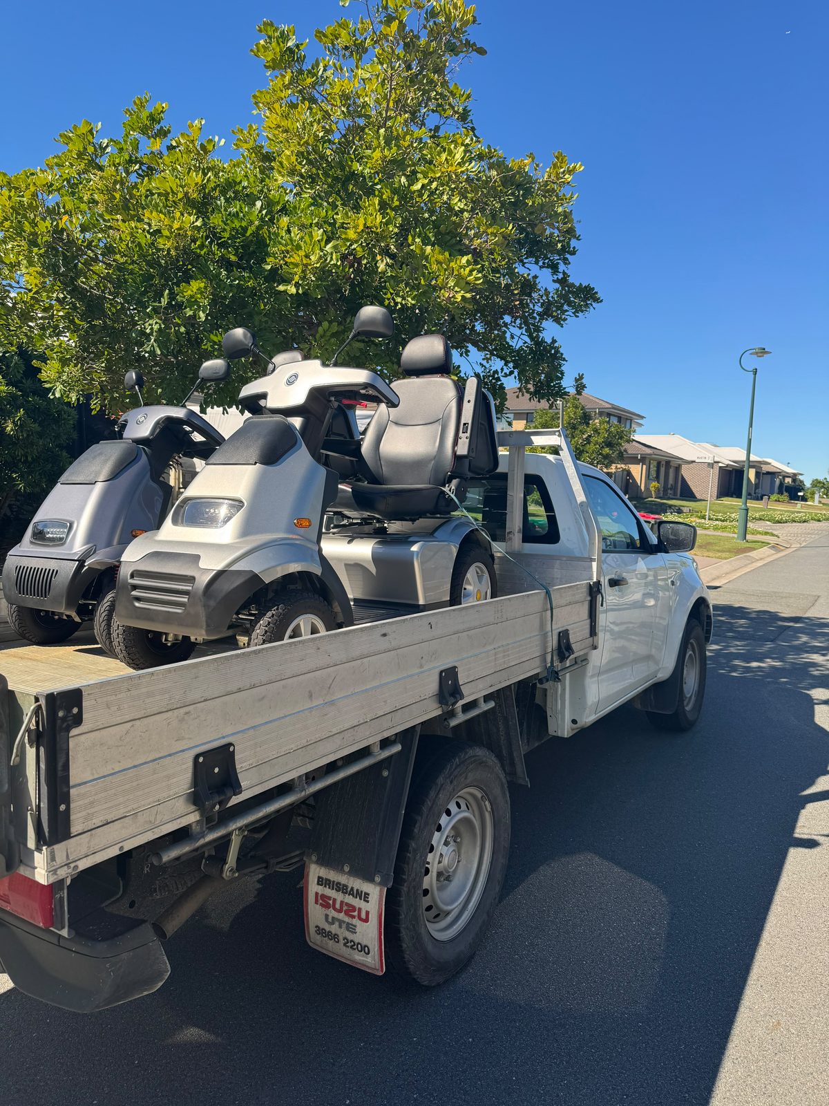 Two mobility scooters loaded on a Pickup Pals ute